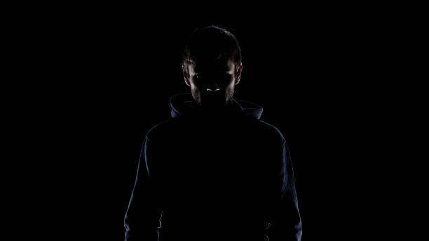 silhouette nera di uomo misterioso che indossa cappuccio, intenzione di commettere reati - uomo incappucciato foto e immagini stock