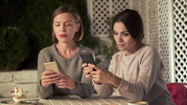 istock Two ladies chatting on phones instead live communication, gadget addiction 1137646255