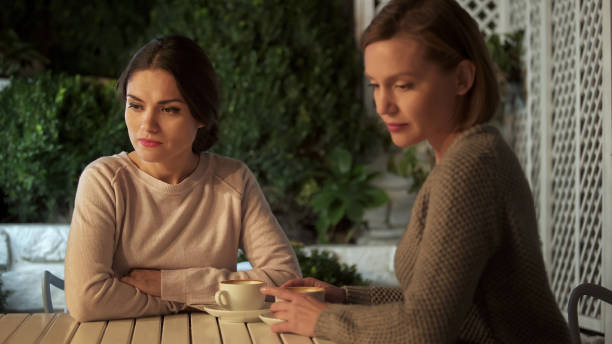 istock Two sad ladies sitting outdoors after quarrel, communication problem, conflict 1137646337