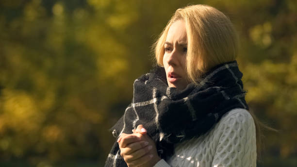 istock Frozen woman in autumn park feeling cold, warming hands, angina disease risk 1137646439