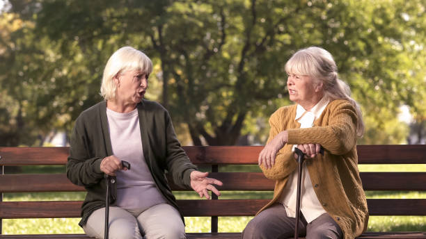 istock Two senior ladies arguing and sitting on bench in park, grumpy elders, dispute 1137646484
