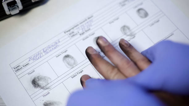 policier dans des gants d’examen prenant des empreintes digitales du suspect, mains en gros plan - criminal photos et images de collection