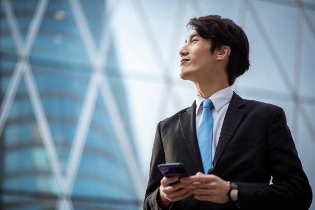 istock Chinese businessman using a smart phone outdoors 1137648288