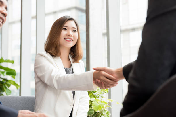 istock Asian business woman making handshake with client in office lounge 1137648401