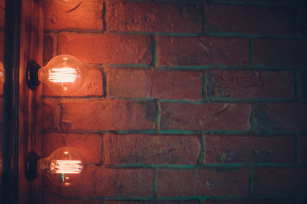 istock Decorative antique edison style light tungsten bulbs against brick wall background. 1137648478