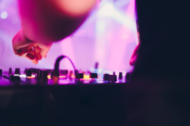 istock DJ playing music at mixer on colorful blurred background. 1137648500