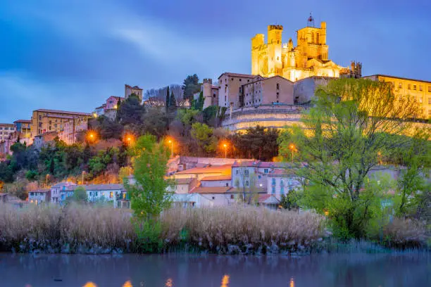 Cathedral and Pont Vieux at night. Beziers, southern France. Beautiful night illumination of medieval architecture.