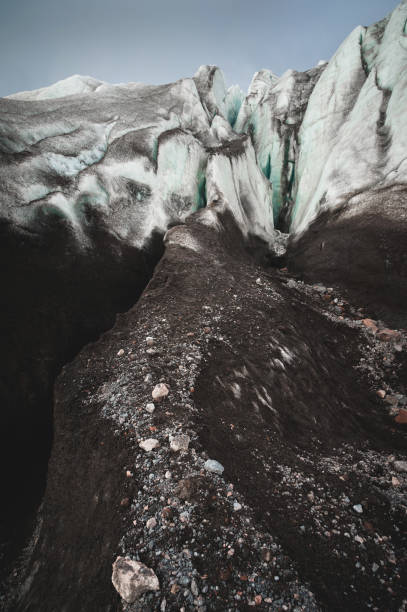 zbliżenie crack jest ciemnoniebieski pęknięcie znaleźć w pokrywie lodowej i czarne błoto na lodowcu. szeroki kąt i dramatyczne niebo - ice arctic crevasse glacier zdjęcia i obrazy z banku zdjęć