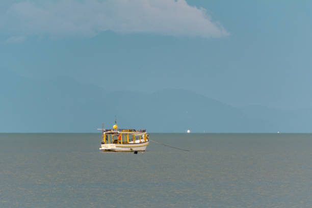 Small boat moored on tranquil sea under a clear blu sky in Caraíva, Northeastern Brazil