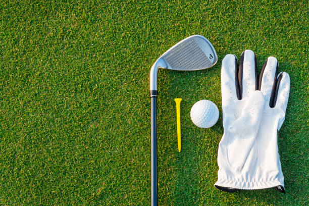 the golf sport equipment  white glove ,golf ball, golf club and  yellow tee golf with green grass background. - tee golf golf club ball imagens e fotografias de stock