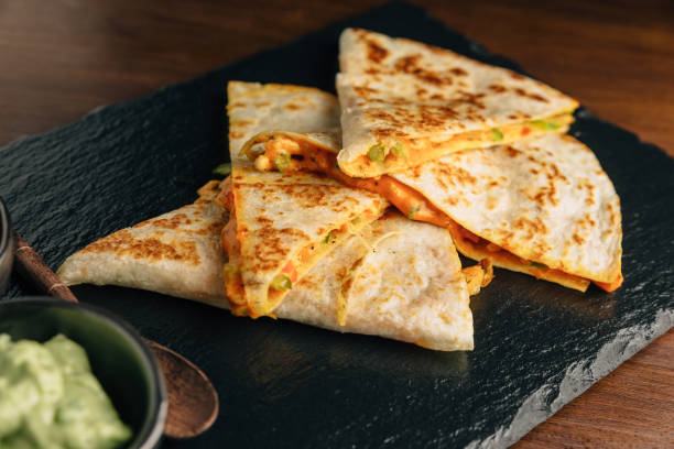 da vicino quesadillas di pollo al forno e formaggio servito con salsa e guacamole su piatto di pietra. - parsley cilantro herb freshness foto e immagini stock