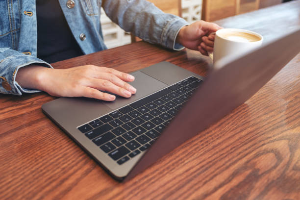 istock a woman using and touching on laptop touchpad on wooden table while drinking coffee 1137683388