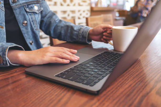 istock a woman using and touching on laptop touchpad on wooden table while drinking coffee 1137683496