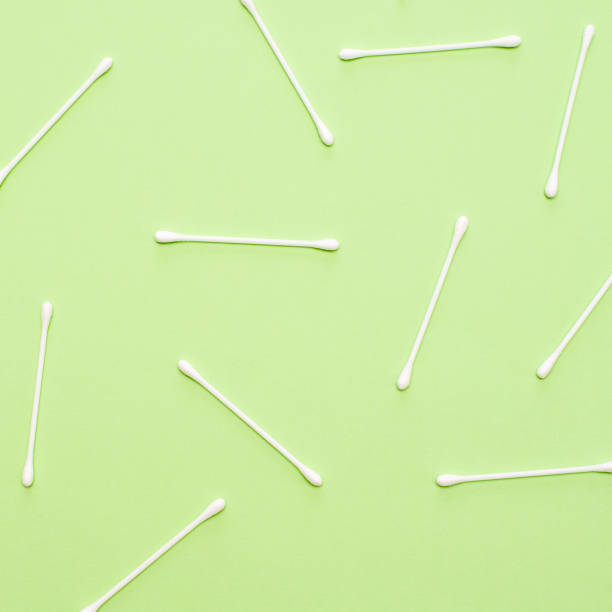istock White cotton swabs on green background lie in random order. 1137689430