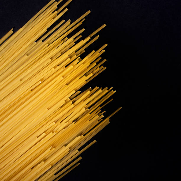 Raw flat spaghetti on black background