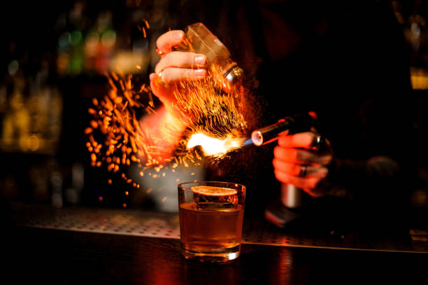 istock Professional bartender adding to a cocktail brown spice and flame it 1137705417