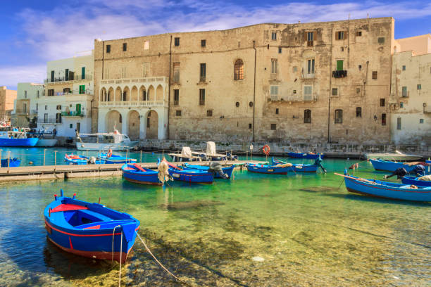 Old port of Monopoli province of Bari, region of Apulia, southern Italy: view of the old town with fishing and rowing boats, Italy. Monopoli represents, on the Adriatic, one of the most active and populous ports in Apulia. It's characteristic historical center of high-medieval origin, superimposed on the remains of a fortified Messapic overlooks the sea surrounded by high walls. monopoli puglia stock pictures, royalty-free photos & images