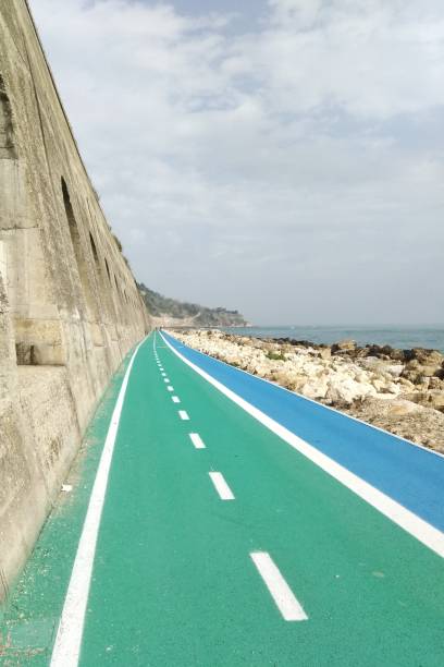 Pedestrian Walkway By Beach Against Sky