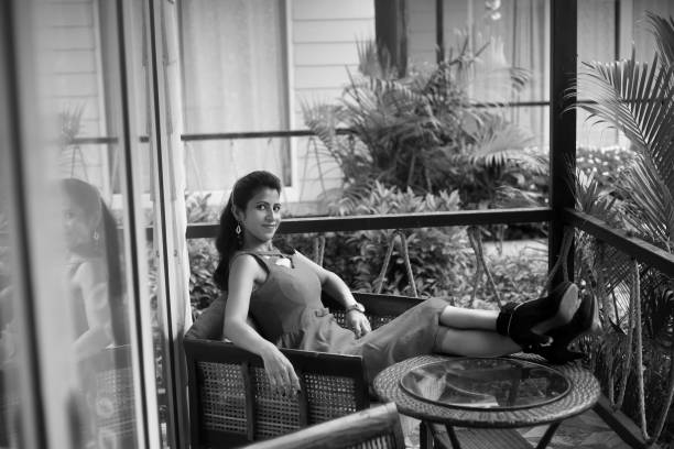 Beautiful young girl resting or relaxing in balcony of luxury tourist resort in Goa.