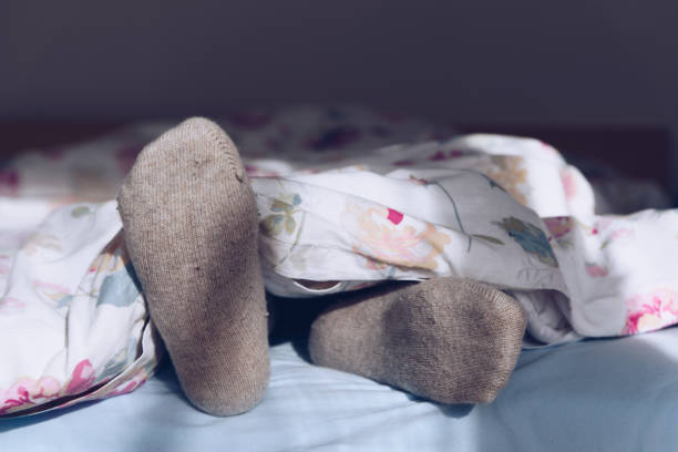 여성 피트에 따뜻한 모직 양말, 여자 자 고 침대에서 휴식 스톡 사진