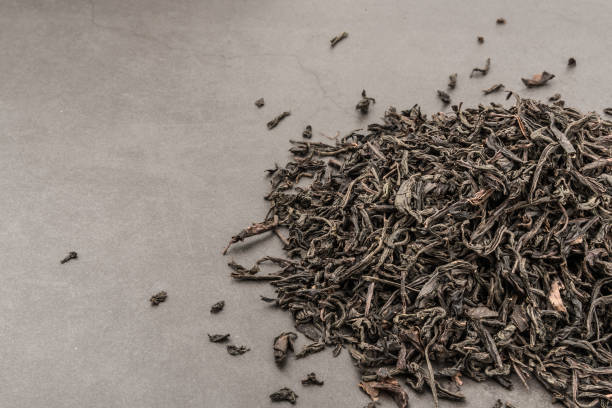 istock Dried tea is poured scattered on a grey textured background. 1137718027