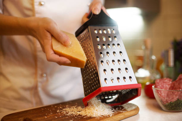 cook rubs cheese - recipe ingredient grater cheese grater imagens e fotografias de stock