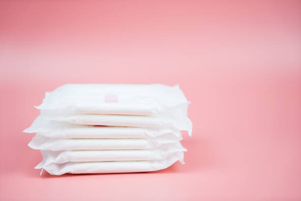 Stacked sanitary napkin pad on pink background. stock photo