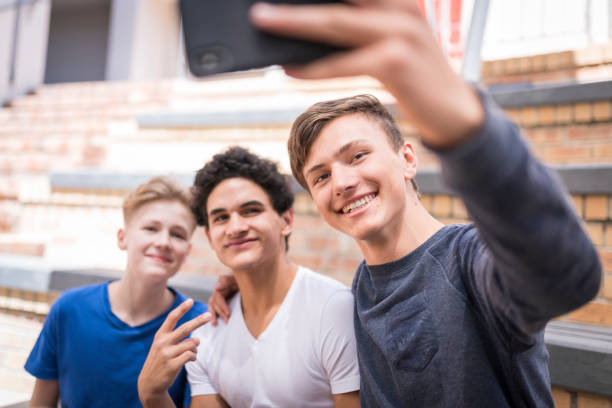istock Smiling friends taking selfie in school campus 1137725747