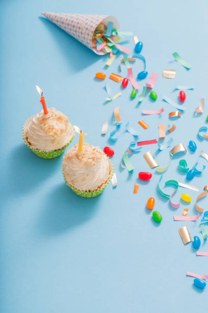 istock birthday hat with confetti and cupcake on blue paper background 1137728505