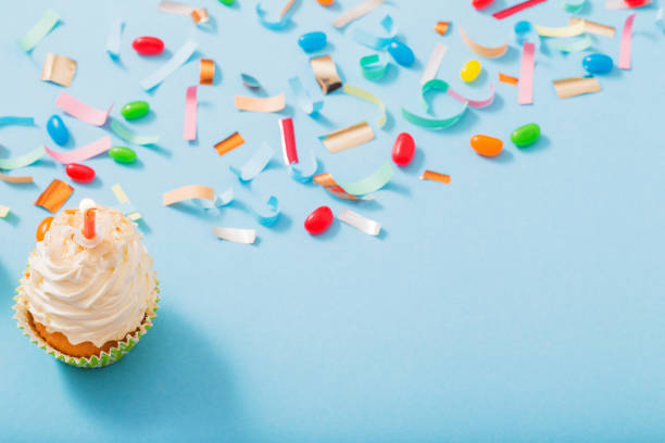 istock birthday hat with confetti and cupcake on blue paper background 1137728512