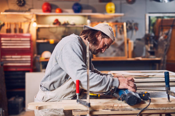 istock Male carpenter working on old wood in a retro vintage workshop. 1137729295
