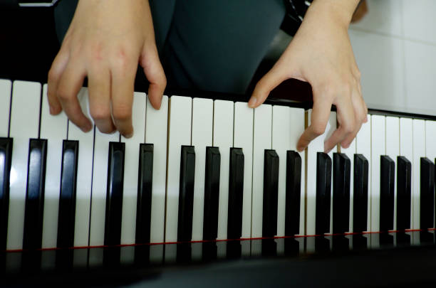 istock close-up female hand playing grand piano. 1137730592