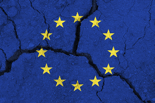 EU flag on the cracked earth. Europe flag. Earthquake or drought concept. brexit