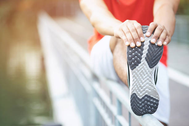 istock young man runner stretching for warming up before running or before a morning workout working out jogging in the park. track and field athlete exercise. Fitness and sport healthy lifestyle concept. 1137734370