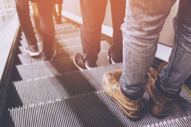 close up legs shoes people crowd using escalator electronic system moving. vintage filter. Staircase Escalator Inside the Underground Metro Subway Station.