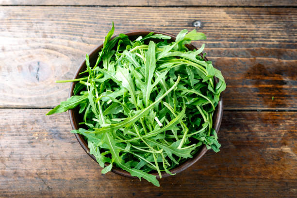 istock fresh arugula salad in a clay plate on the table. 1137736939