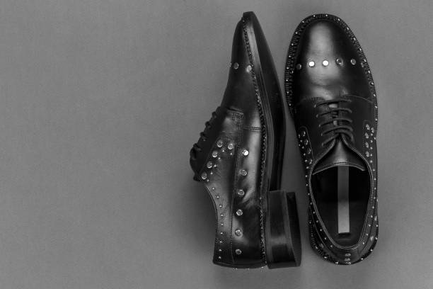 istock Women's black oxfords with metal rivets on a dark gray background. 1137738262