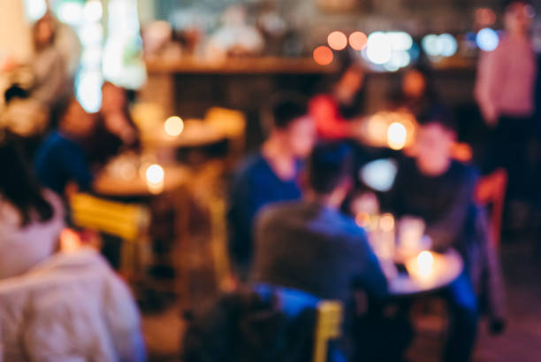 Crowded Downtown Café Defocused group of people is sitting in downtown café busy restaurant tables stock pictures, royalty-free photos & images