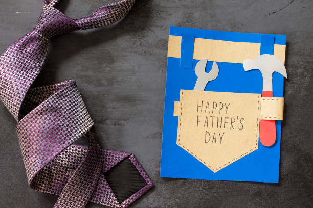 istock Greeting card with Happy fathers day and tie on grey stone table.  Top view flat lay background. 1137743387