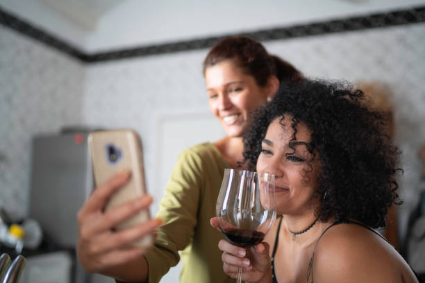 istock Lesbian Couple Portrait Drinking Wine and Taking a Selfie at Kitchen 1137743693
