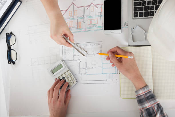 istock Architects working on blueprint, real estate project. Architect workplace - architectural project, blueprints, ruler, calculator, laptop and divider compass. Construction concept. Engineering tools. 1137747466