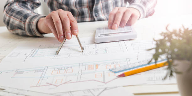 architects working on blueprint, real estate project. architect workplace - architectural project, blueprints, ruler, calculator, laptop and divider compass. construction concept. engineering tools. - housing project organization meeting real estate imagens e fotografias de stock