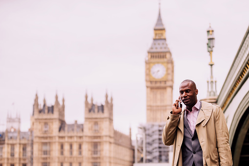 London, Businessman, Confidence, England -  Business Executive near Westminster Bridge talking on the phone during his morning commute