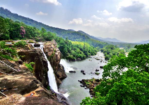 Waterfall in the Western Ghats , India At the edge of the Athirapally Waterfall in Kerala, with a stunning view of the surrounding jungle and mountains - Kochi, India (Cochin) kerala photos stock pictures, royalty-free photos & images