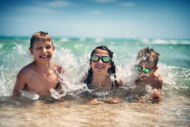 istock Kids playing in sea waves 1137754817