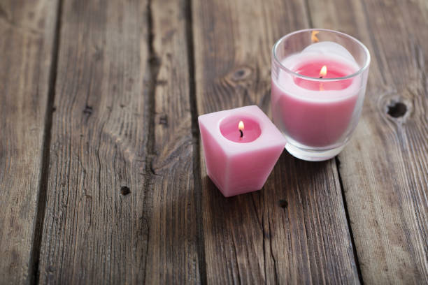 istock pink candles on old wooden background 1137755554