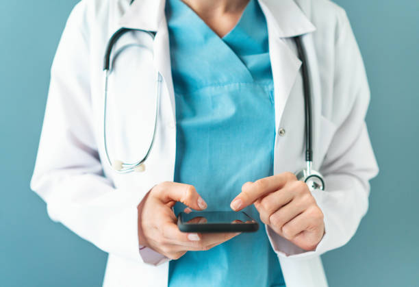 istock Doctor using smartphone in front of a bright background 1137759940