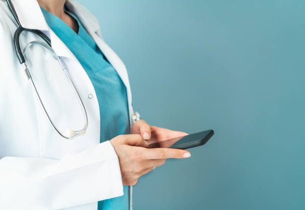 istock Doctor using smartphone in front of a bright background 1137759944