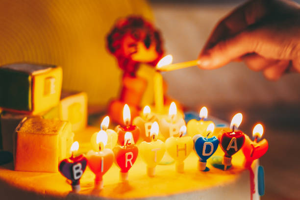 Happy Birthday Written In Lit Candles On Colorful Cake Background