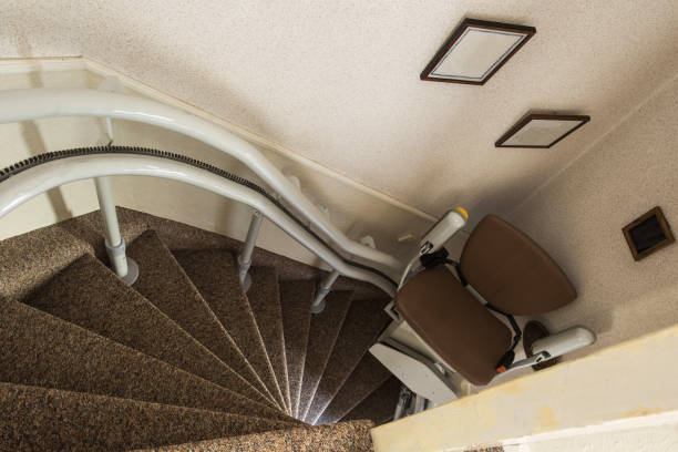 Mechanical chair lift taking disabled or aged people up and down stairs Senior, Stairlift for disabled stock photo